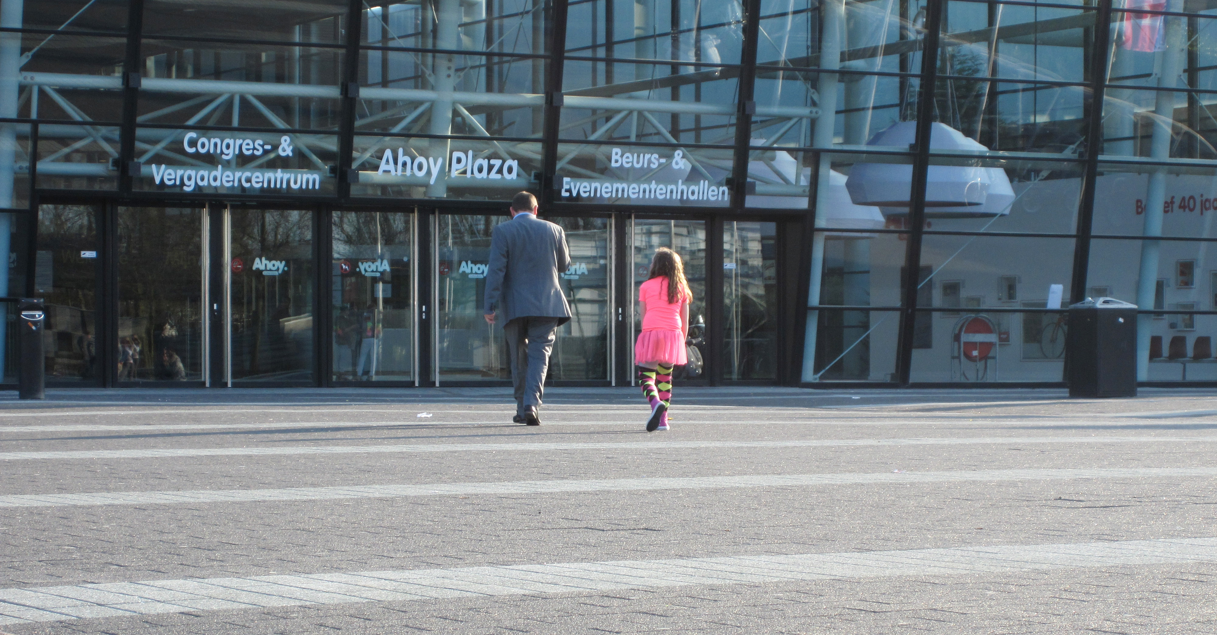Een pappa die met z'n dochtertje richting kassa loopt om de kaartjes op te halen.